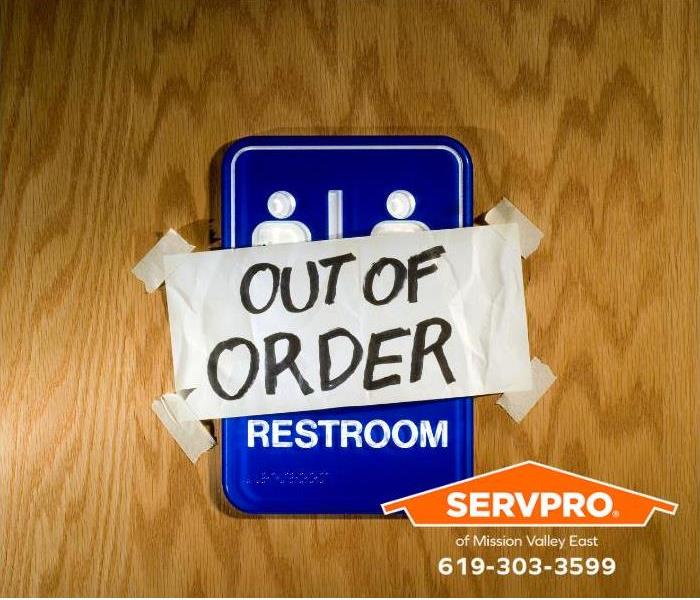 An “out of order” sign sits outside a men’s bathroom.